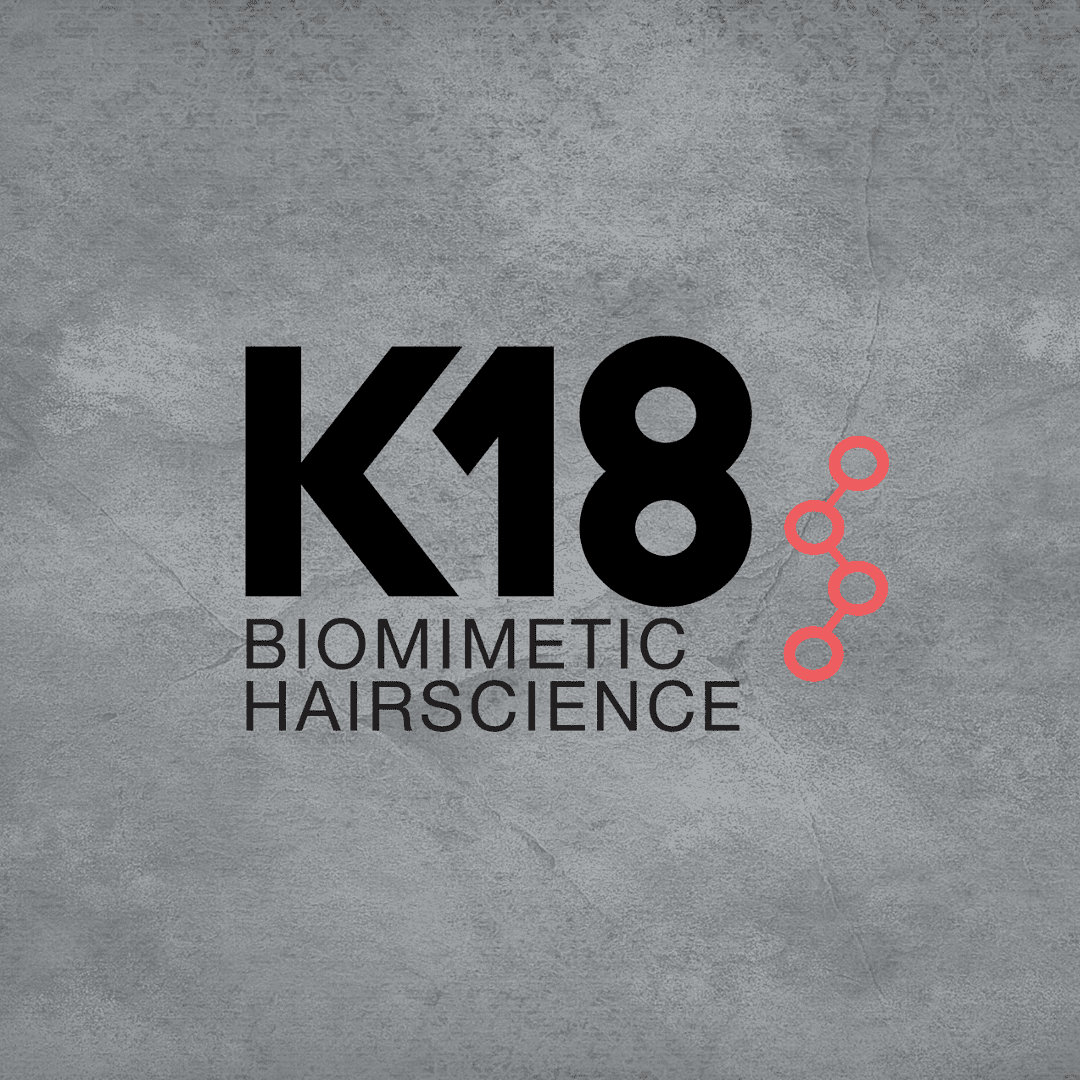 K18 Biomimetic Hairscience logo with a gray textured background and red molecular design.